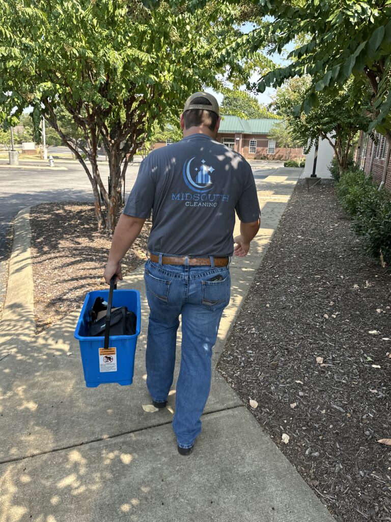 Midsouth Cleaning technician walking to job site carrying cleaning supplies.