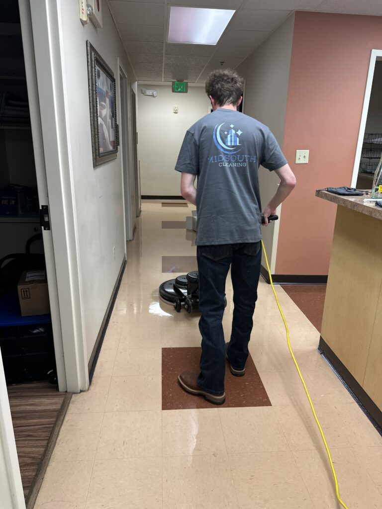 Midsouth Cleaning technician polishing commercial hallway floor with professional floor buffer.