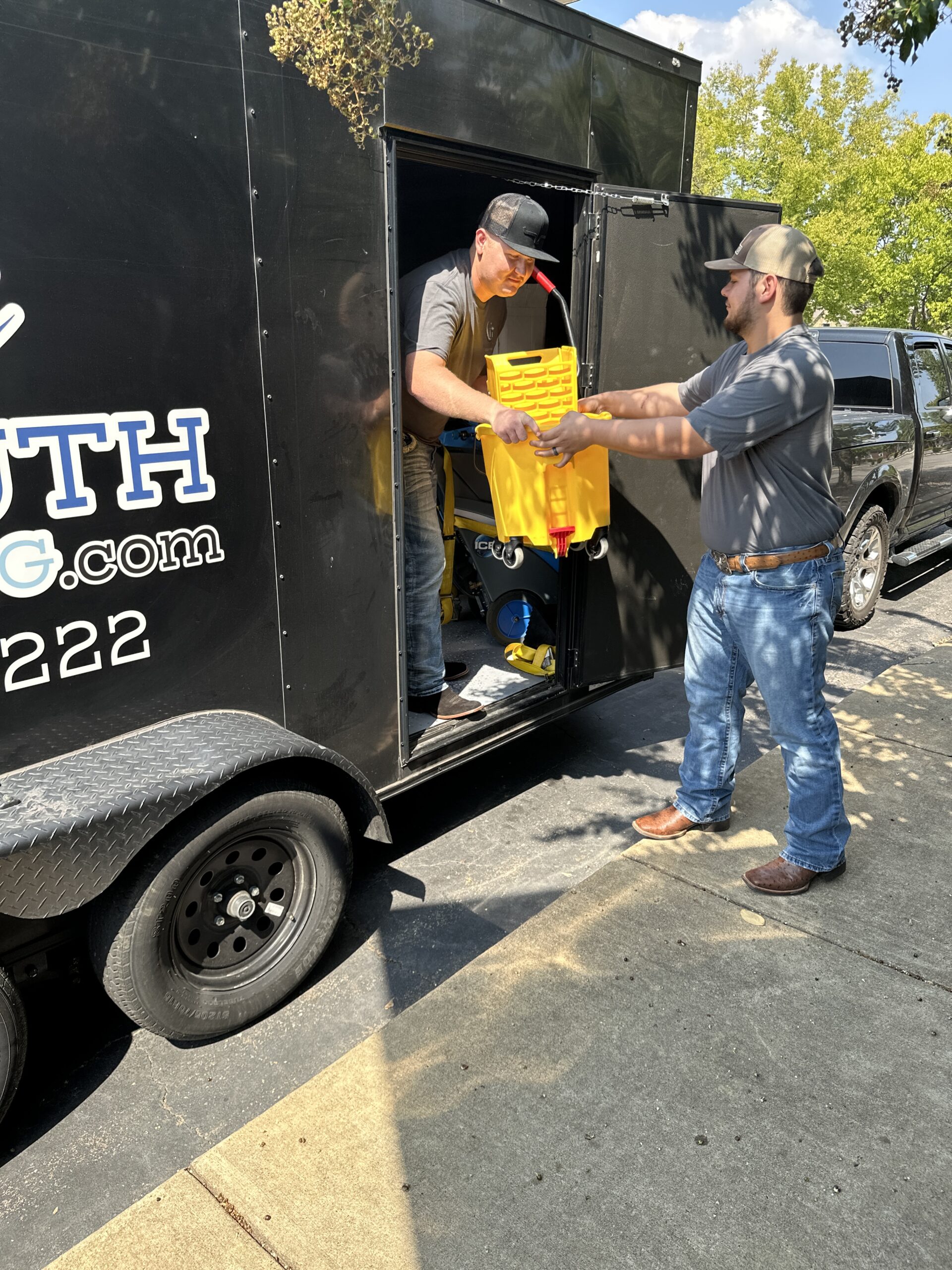 Midsouth Cleaning crew unloading janitorial equipment from service trailer for a cleaning project.