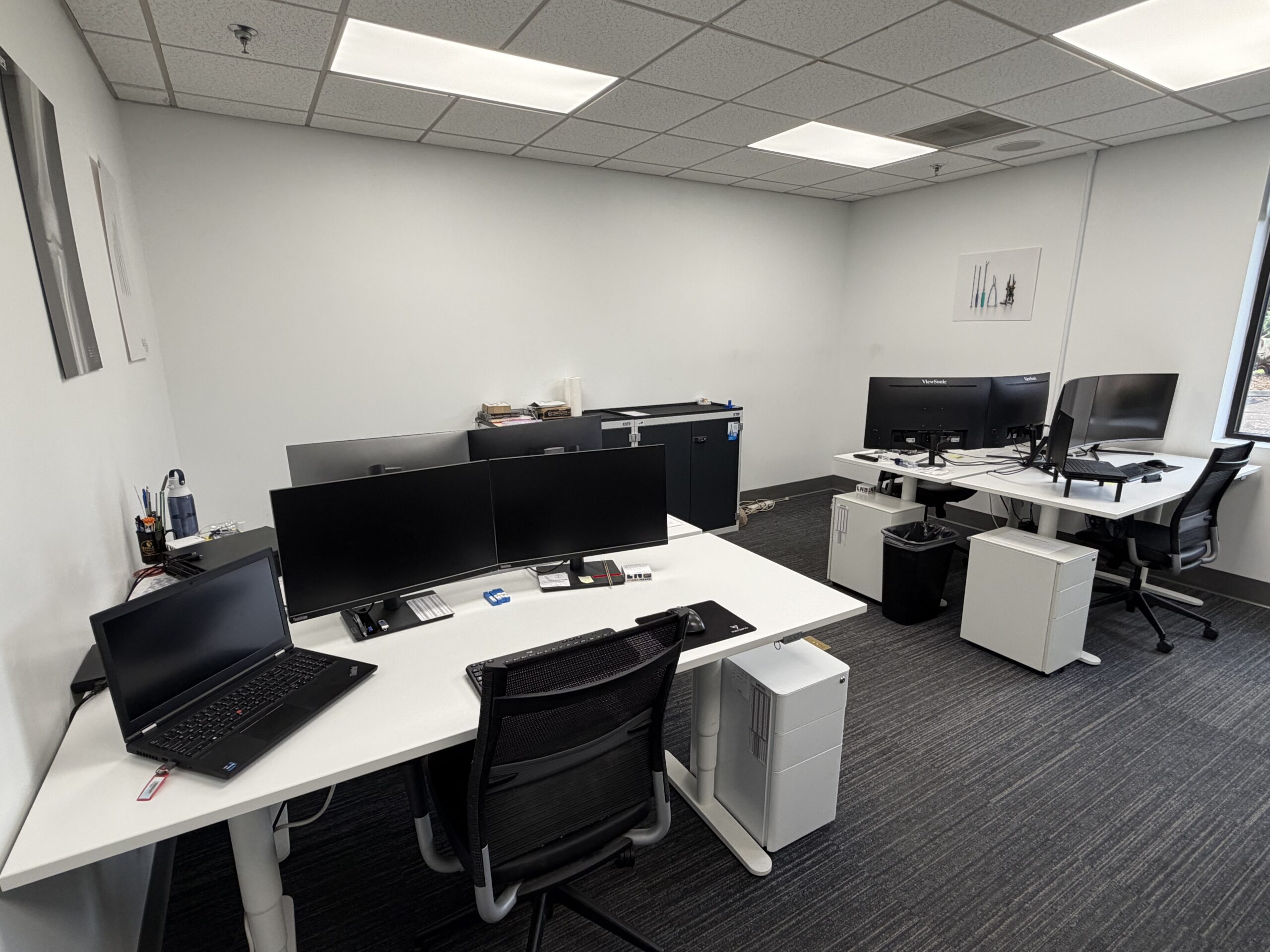 Clean and organized office workspace with multiple computer desks after professional cleaning.