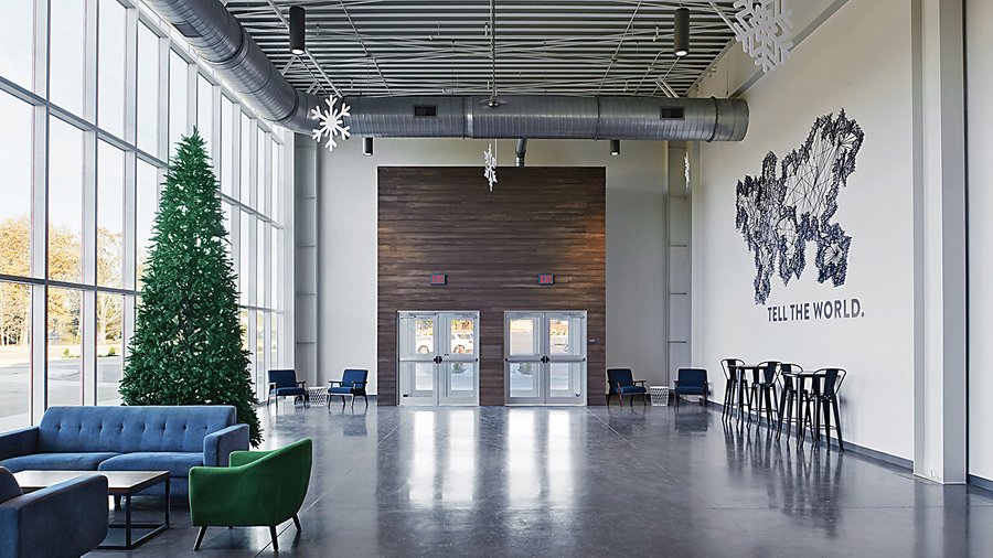 Clean and modern church lobby with polished floors, high ceilings, and Christmas decorations.